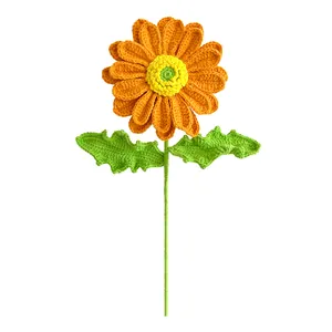Handmade crochet sunflower with orange petals and green leaves for festive home decoration