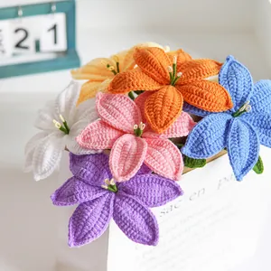 Handmade crochet lily bouquet with vibrant colorful flowers in a white paper bag