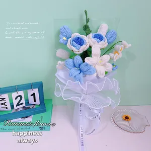 Détail d'un bouquet au crochet fait main avec roses bleues et lys blancs sous tulle