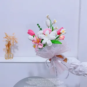 Gros plan d'un bouquet tricoté main avec lys et tulipes sous filet rose doux