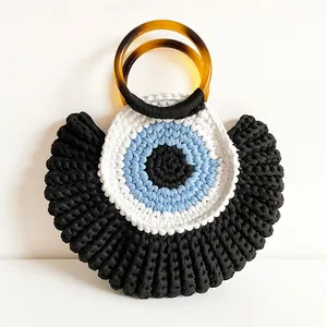 Macro detail of the hand-woven cotton texture and tortoiseshell resin handles of the bag