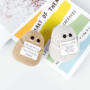 Nahaufnahme handgestrickter positiver Kartoffeln in Braun und Grau mit kleinen Karten