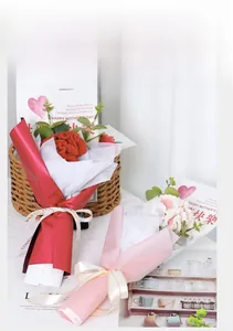 Close-up of handmade knitted carnation bouquet with Love Eternal ribbon and wrapping paper