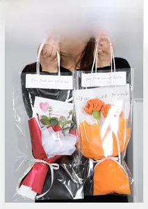 Hand-knitted crochet flower bouquet in a transparent gift bag with ribbon and card