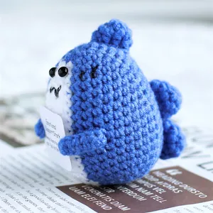 Close-up of handmade crochet emotional support shark doll with a positive card