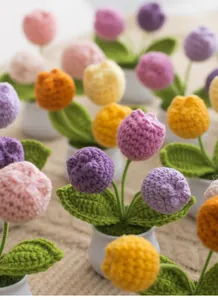 Close-up of handmade crochet tulip potted plant with vibrant pink knitted petals