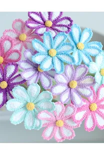 Macro detail of hand-crocheted yarn flowers in pastel purple, pink, and mint green colors