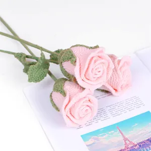 Détail de trois roses roses crochetées à la main sur un magazine pour décoration