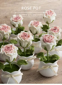 Detail of hand-knitted rose pots with textured white containers and ribbon bows