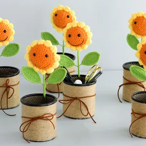 Detail of handcrafted crochet sunflower pen holder with smiley face and hemp rope bow