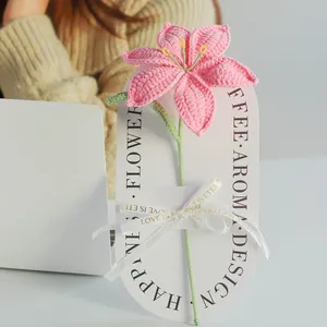 Bouquet de lys roses tricotés main avec ruban décoratif sur carte d'affichage