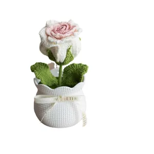 Handmade crochet rose potted plant with pink petals and a white textured decorative pot