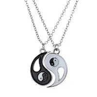 Detailweergave van de in elkaar grijpende yin yang hangers aan zilveren kettingen