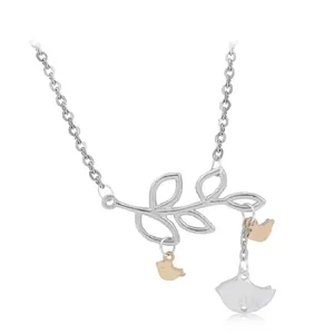 Close-up of bird on branch pendant necklace with silver and rose gold bicolor details