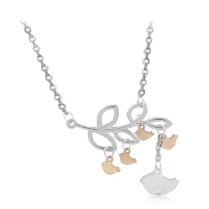 Detailed view of silver branch pendant with three rose gold birds and one silver bird