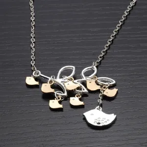 Detail shot of a branch-shaped pendant with seven gold and one silver bird charms