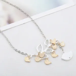 Minimalist silver necklace featuring birds on a branch pendant with two-tone finish