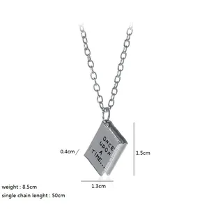 Detailed view of silver storybook pendant engraved with Once Upon a Time on white background