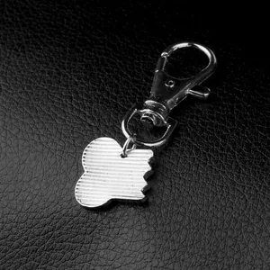 Silver apple shaped metal keychain with textured finish and lobster clasp on black leather