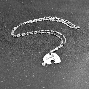 Detail view of silver puzzle piece necklace with Middle sis engraving and lobster clasp