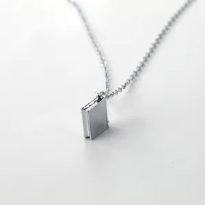 Silver book-shaped pendant necklace featuring a polished mirror finish and detailed spine