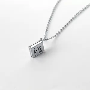 Detail of silver storybook pendant with Once Upon a Time engraving and fine chain