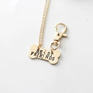 Detail van Best Friends gedeelde bot ketting en sleutelhanger set in gouden afwerking