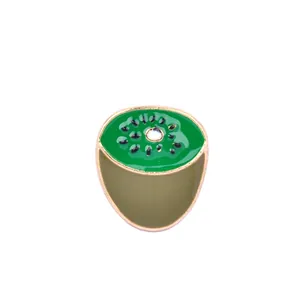 Macro detail of kiwi fruit enamel pin with green pulp and gold metal edging