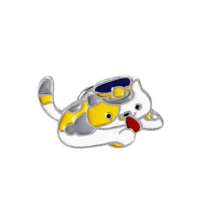 Cartoon calico cat enamel brooch with uniform cap and playful tongue on white background