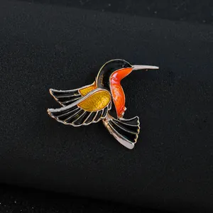 Eleganter Kolibri-Anstecknadel mit schwarz-orangefarbener und gelber Emaille im Flug