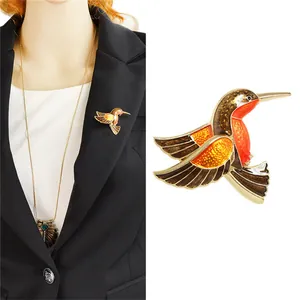 Bunte Kolibri-Brosche aus goldener Legierung mit Emaille auf einem schwarzen Blazer