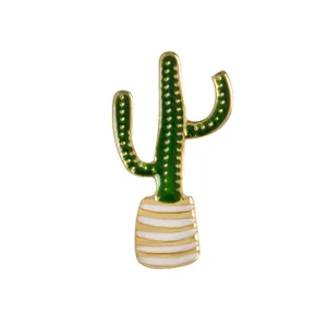 Dettaglio di una spilla a cactus in smalto dorato con finitura verde e vaso bianco