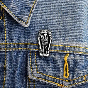 Detail der Emaille-Anstecknadel mit Skelett und Forever Ever Text auf Jeansjacke