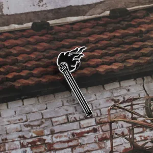 Black and white burning matchstick enamel pin brooch with a creative flame design