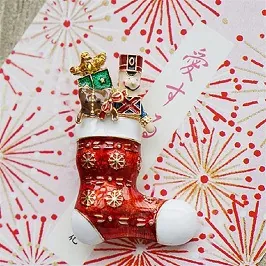 Detailansicht einer Weihnachtsstrumpf-Brosche mit Nussknacker und festlichen Motiven