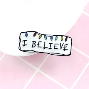 Broche rectangulaire en émail avec petites lumières colorées et texte I BELIEVE