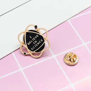 Golden enamel atomic orbit pin with I Believe in Science slogan for denim jackets