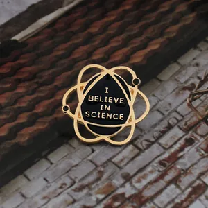 Macro shot of Atom Science Enamel Pin with I Believe In Science text on jacket collar