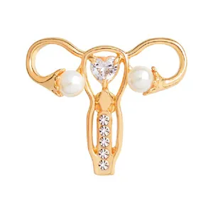 Uterus shaped enamel brooch in gold alloy with pearls and heart-shaped zircon stones