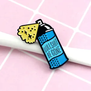 Blue spray can enamel pin featuring BULLSHIT BE GONE slogan on pink checkered background