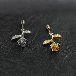 Elegantes broches de esmalte de rosa en oro y plata sobre una superficie negra texturizada