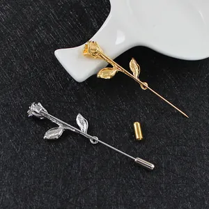 Detalle de broches de rosa elegantes en oro y plata con agujas largas y finas sobre fondo