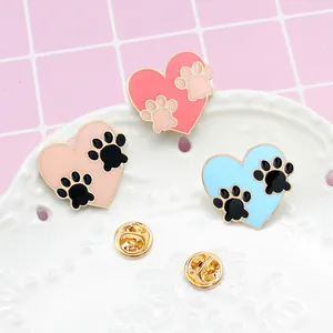 Drie emaille hartspelden met pootafdrukken in roze en blauw op gouden plating