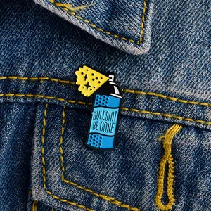 Detail of blue spray bottle enamel pin with 'BULLSHIT BE GONE' on denim jacket pocket
