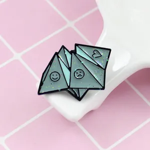 Blue geometric origami enamel pin with glitter finish and assorted smiley face expressions