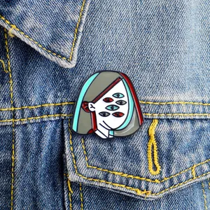 Detailansicht der Picasso-Stil Emaille-Anstecknadel auf einer blauen Jeansjacke