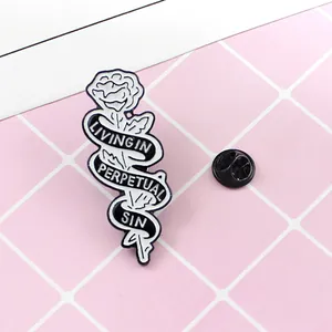 Detalle macro de pin de rosa esmaltada con cinta grabada sobre fondo de cuadrícula