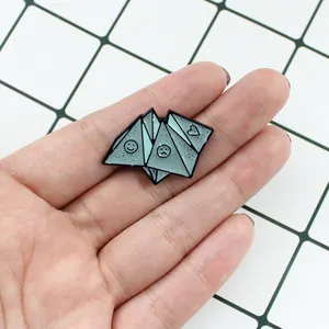 Detail of mint green enamel origami brooch with glitter finish and emotional face patterns