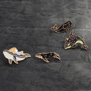 Lot de quatre broches en émail baleine aux motifs ciel étoilé et aux bordures dorées