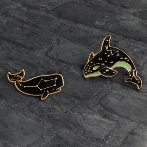 Détails macro des broches baleine en émail avec constellations dorées sur pierre